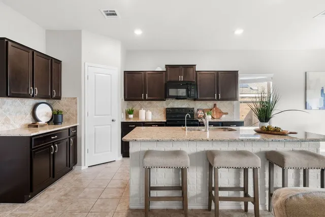 a kitchen with stainless steel appliances granite countertop a stove a sink and a refrigerator