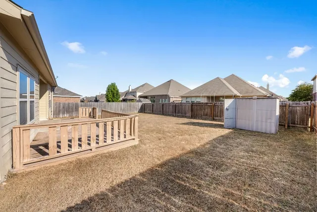 a view of a house with a yard and wooden fence