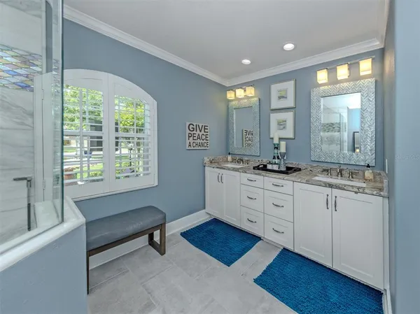 a spacious bathroom with double vanity and a mirror