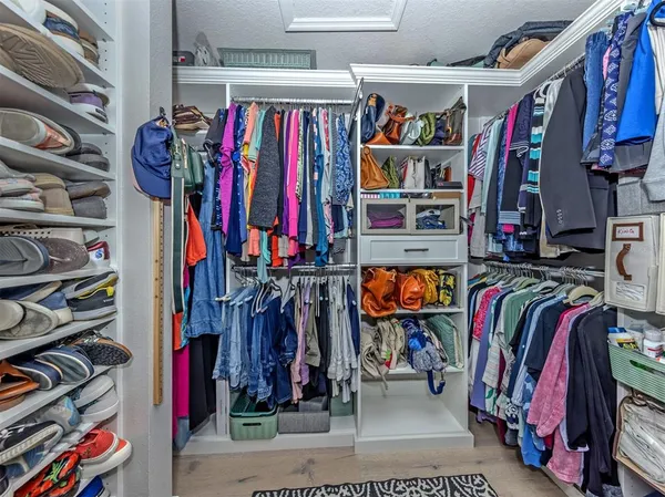 a view of walk in closet with clothes and shoes