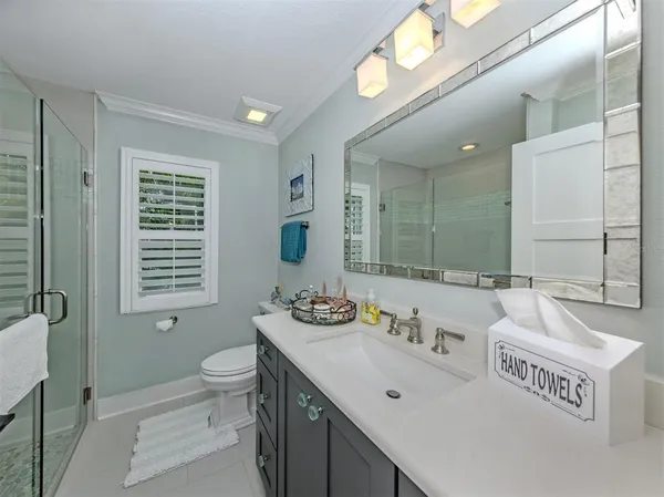 a bathroom with a sink a toilet and a large mirror