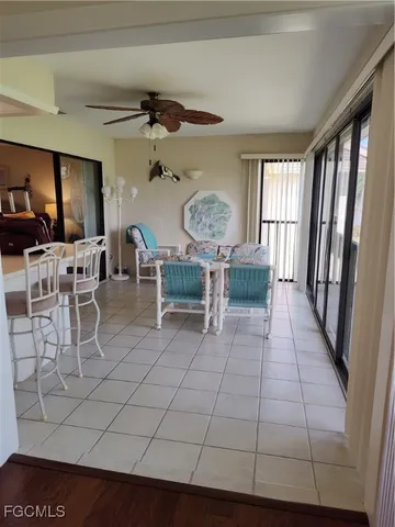 a living room with furniture a flat screen tv and kitchen view