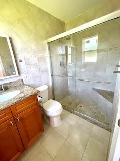 22175 General Street Boca Raton, FL 33428 - Photo 26 of 32 a bathroom with a granite countertop bathtub shower and toilet