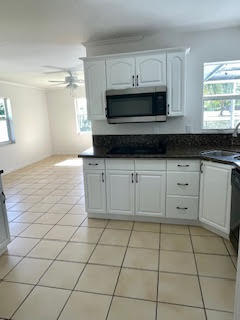 22175 General Street Boca Raton, FL 33428 - Photo 30 of 32 a kitchen with stainless steel appliances a sink a stove a microwave and cabinets