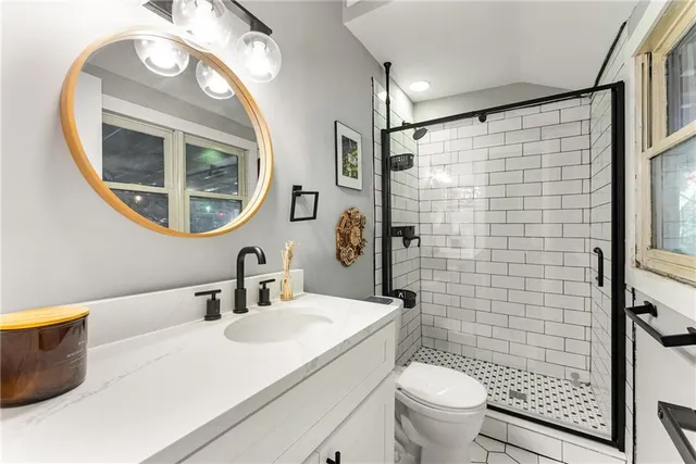 a bathroom with a sink a toilet and a mirror