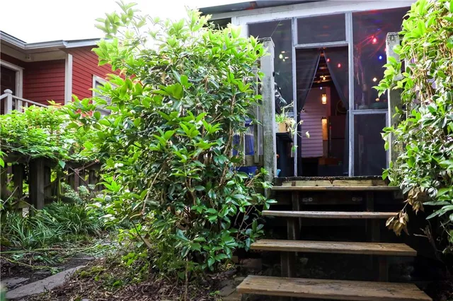 a view of house with a yard and potted plants
