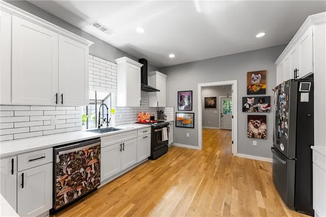 a kitchen with stainless steel appliances granite countertop lots of counter top space and wooden floor