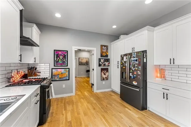 a kitchen with stainless steel appliances granite countertop a refrigerator and stove top oven