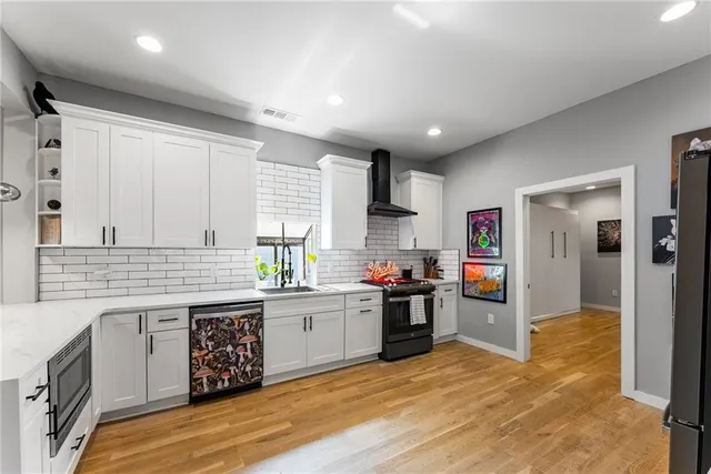a kitchen with stainless steel appliances granite countertop a stove sink and cabinets