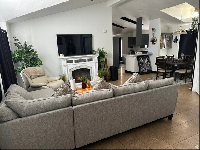265 Mindella Way Layton, UT 84041 - Photo 6 of 32 Open-concept living space featuring a white mantel, an integrated kitchen with a dark range hood, and a dining area with a dark wood table