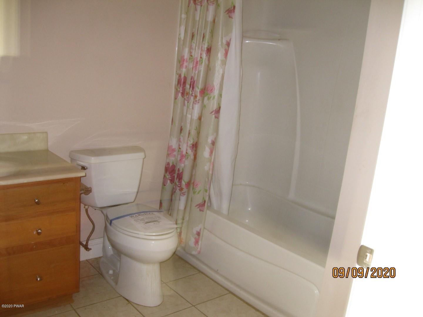 271 North Baker Road Waymart, PA 18472 - Photo 19 of 25 a white toilet sitting next to a bath tub
