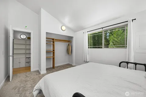 a bedroom with a bed and a large window
