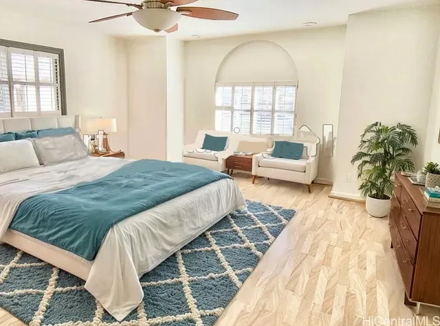 a spacious bedroom with a bed a couch and potted plant with the wooden floor
