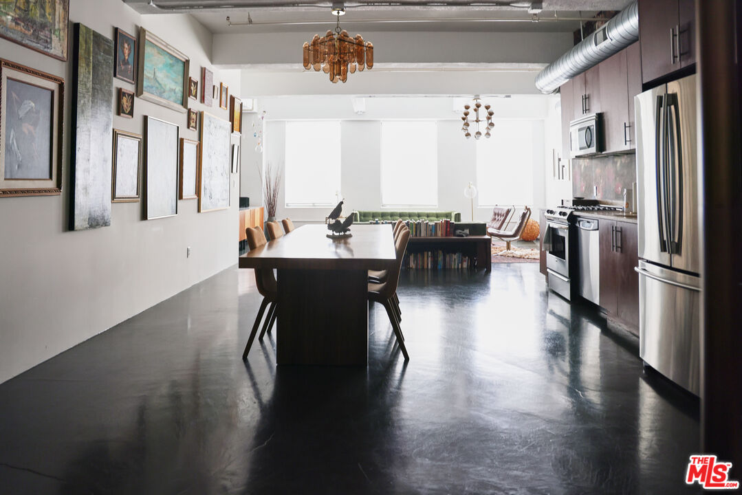 849 South Broadway, Unit 906 Los Angeles, CA 90014 - Photo 22 of 65 a kitchen with stainless steel appliances a dining table chairs and a refrigerator
