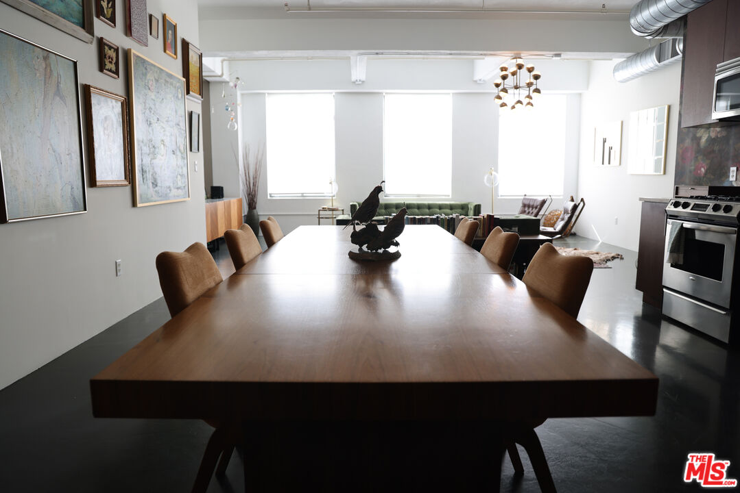 849 South Broadway, Unit 906 Los Angeles, CA 90014 - Photo 25 of 65 a view of a dining room with furniture and a chandelier