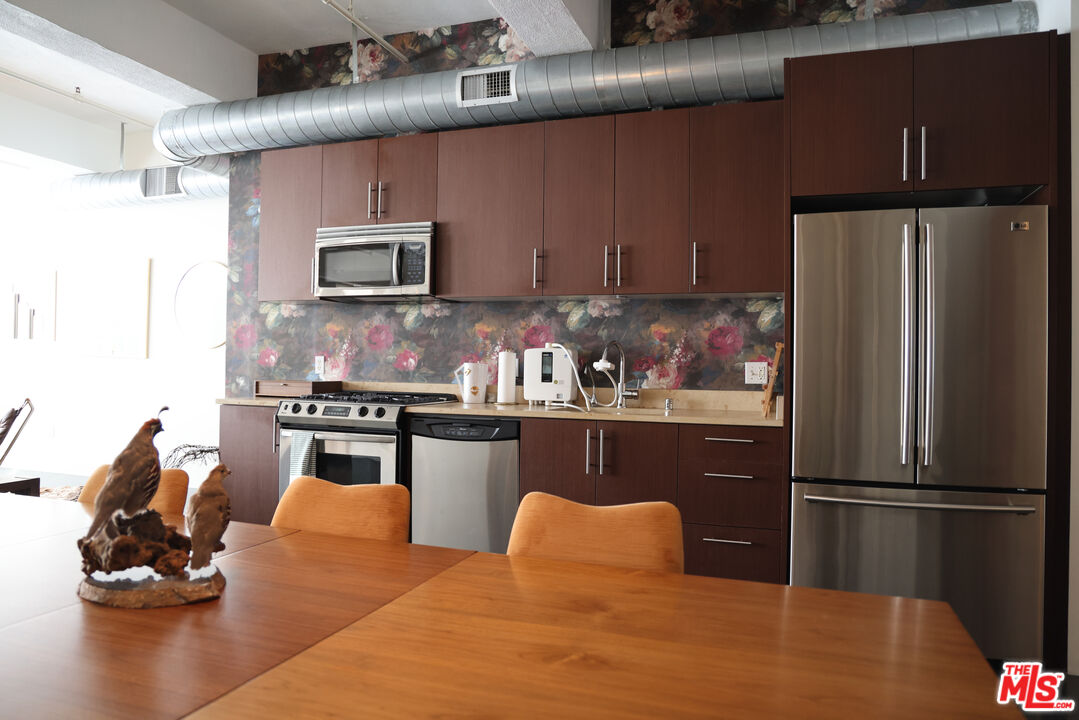 849 South Broadway, Unit 906 Los Angeles, CA 90014 - Photo 27 of 65 a kitchen with stainless steel appliances granite countertop a refrigerator and a sink