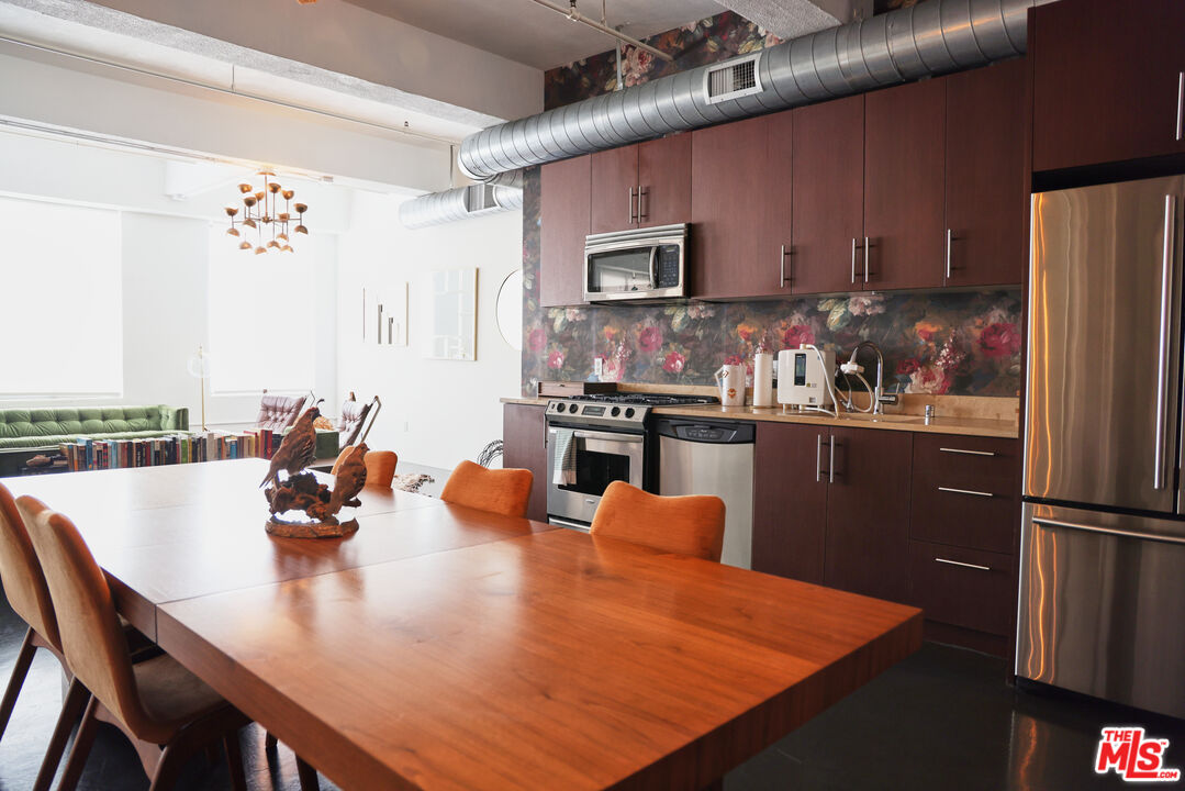 849 South Broadway, Unit 906 Los Angeles, CA 90014 - Photo 28 of 65 a kitchen with stainless steel appliances granite countertop a sink a stove and a refrigerator