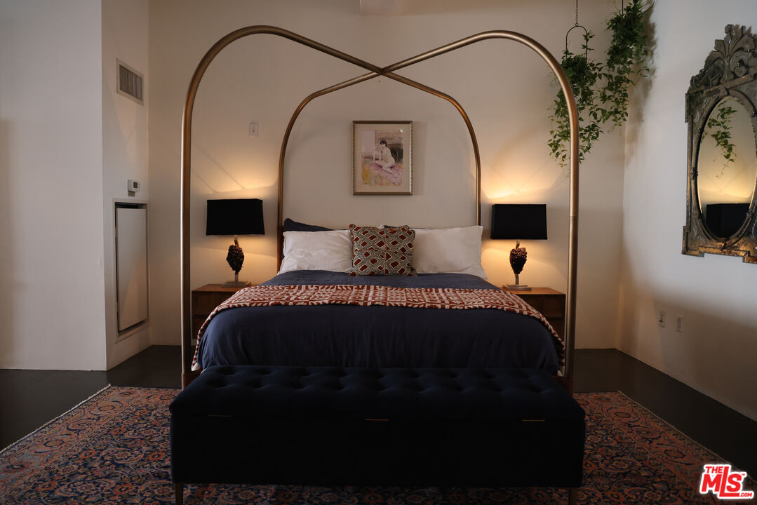 849 South Broadway, Unit 906 Los Angeles, CA 90014 - Photo 29 of 65 a bedroom with a bed and a mirror on dresser