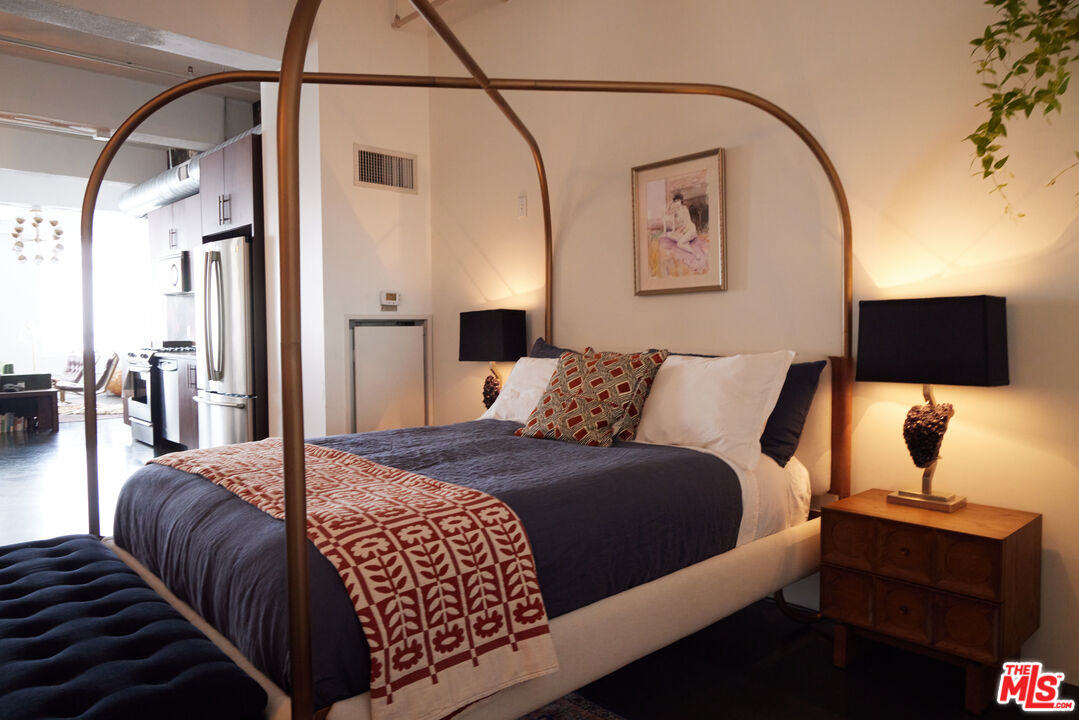 849 South Broadway, Unit 906 Los Angeles, CA 90014 - Photo 41 of 65 a bedroom with a bed and wooden floor