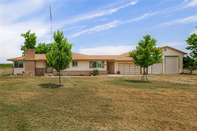 a front view of a house with a garden and yard