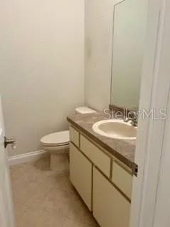a bathroom with a granite countertop sink a toilet and a mirror