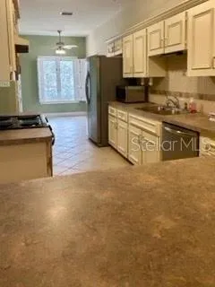 a kitchen with stainless steel appliances granite countertop a refrigerator a stove and a sink