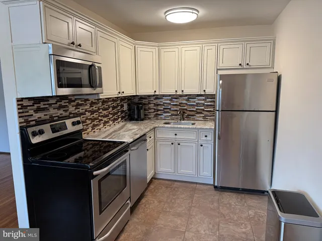 a kitchen with cabinets and steel appliances