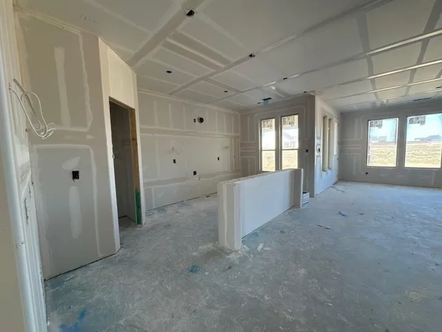 en empty room with windows and entrance