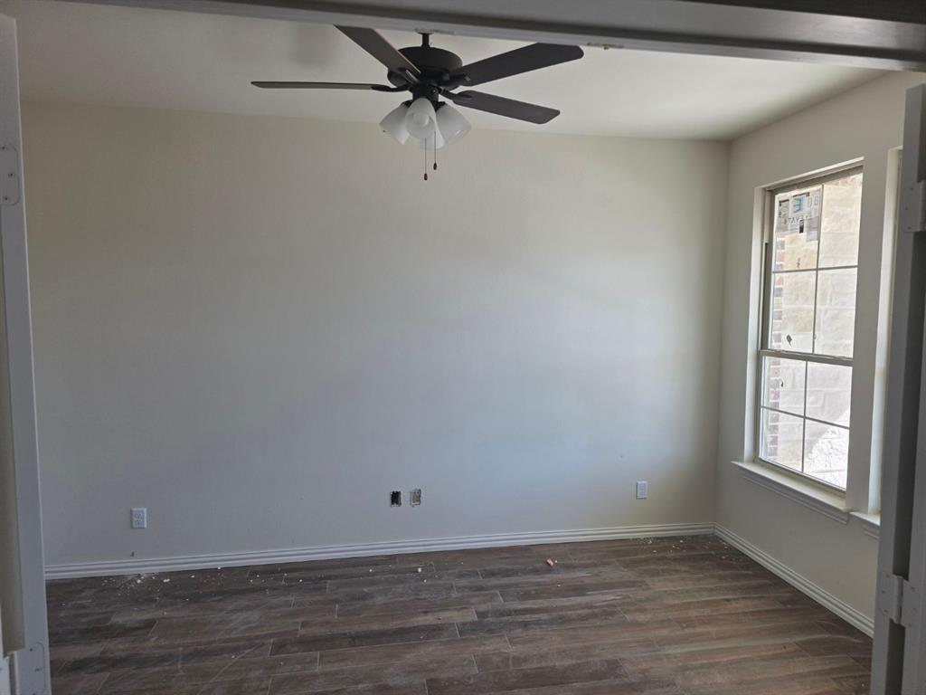 116 Snowy Owl Trail Rhome, TX 76078 - Photo 4 of 7 wooden floor in an empty room with a window
