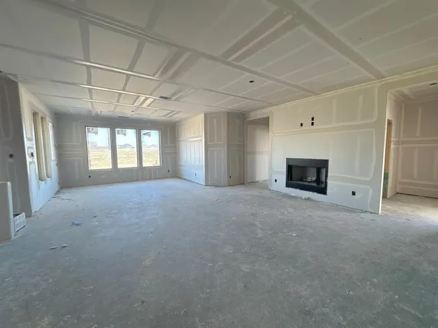 a view of empty room with fireplace and windows