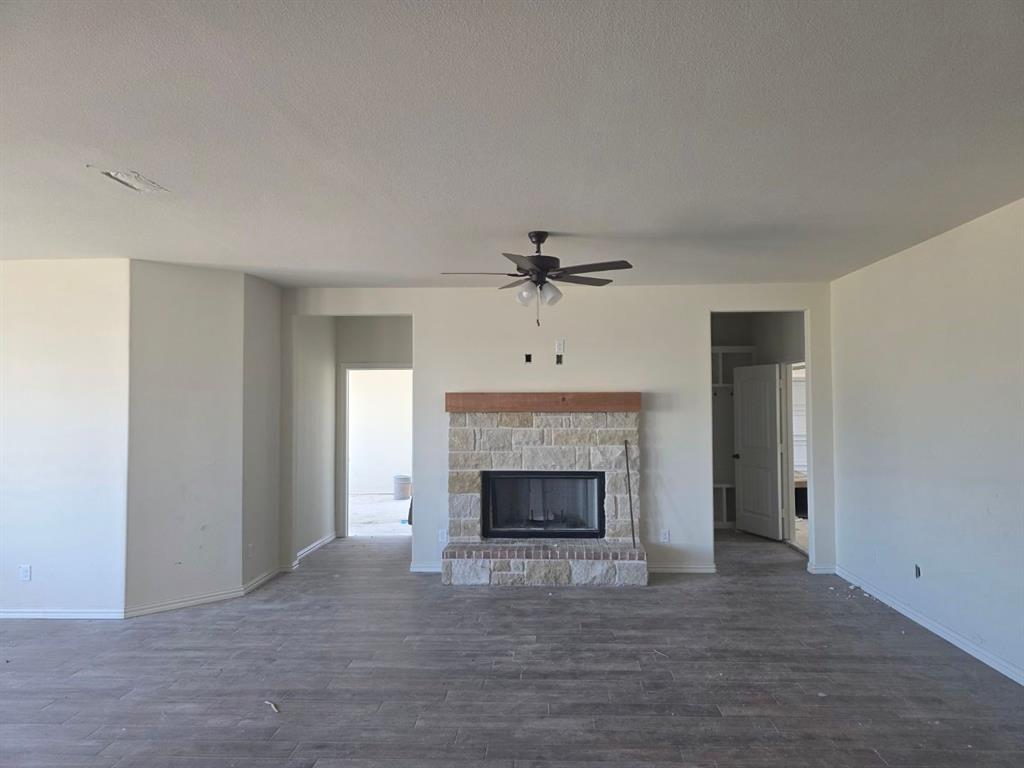 116 Snowy Owl Trail Rhome, TX 76078 - Photo 6 of 7 a view of an empty room with wooden floor fireplace and a window