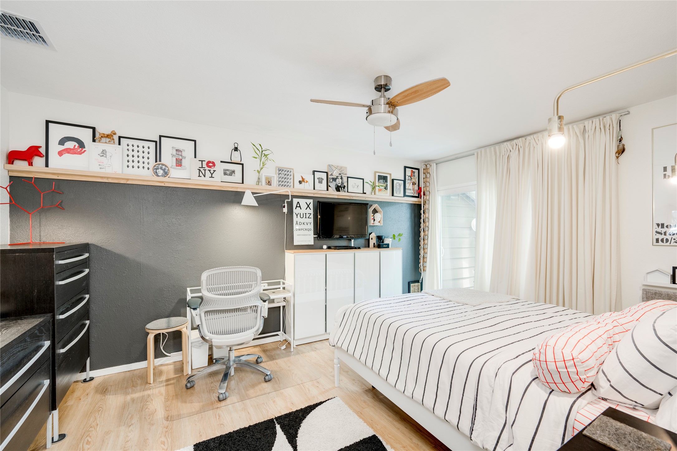 3627 Menchaca Road, Unit 214 Austin, TX 78704 - Photo 18 of 28 A well-lit bedroom features hardwood flooring and a functional work-from-home space.