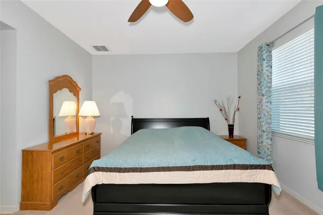 a bedroom with a bed and dresser with mirror