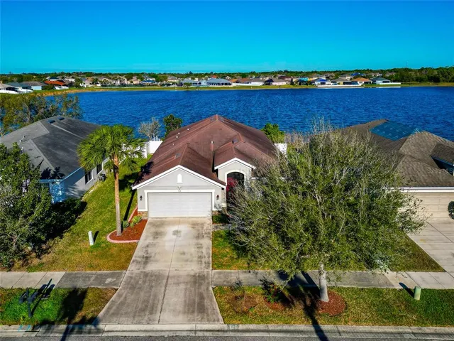 an aerial view of a house with a garden and lake view