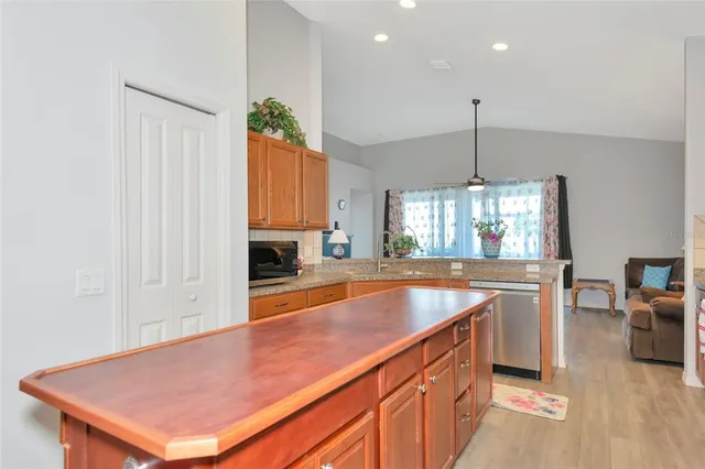 a kitchen with stainless steel appliances granite countertop a sink a stove and a wooden floors