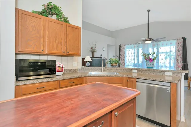 a kitchen with stainless steel appliances granite countertop a stove a sink and a white cabinets