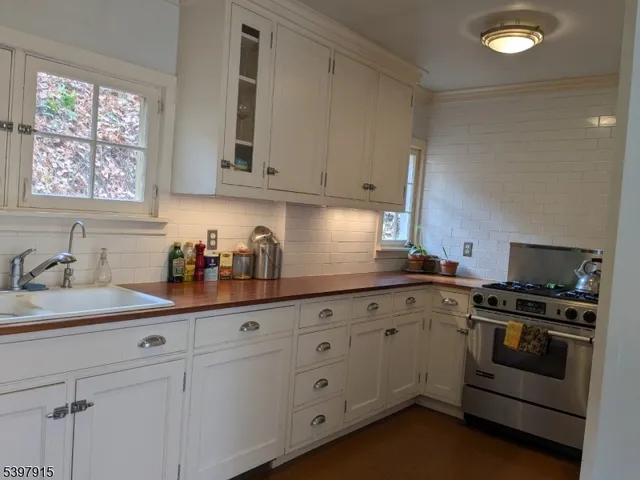 a kitchen with granite countertop white cabinets and white appliances