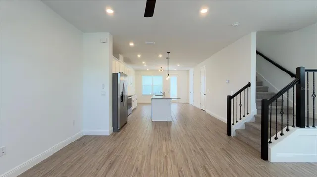 a view of a hallway with wooden floor and staircase