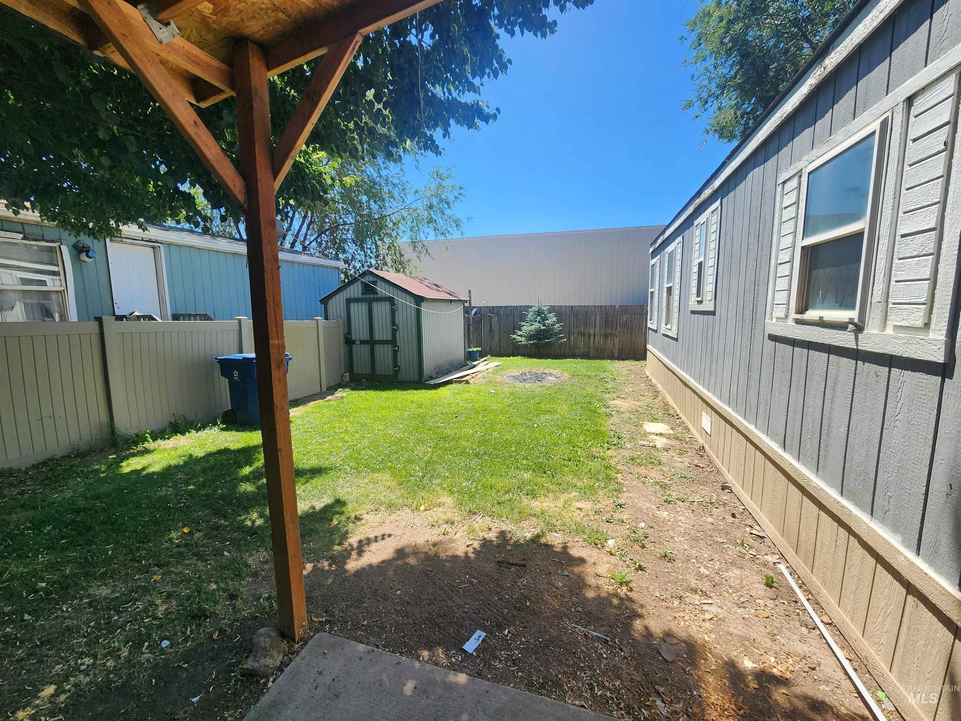 616 North Kings Road Nampa, ID 83687 - Photo 11 of 12 Grassed backyard area featuring a utility shed and privacy fencing