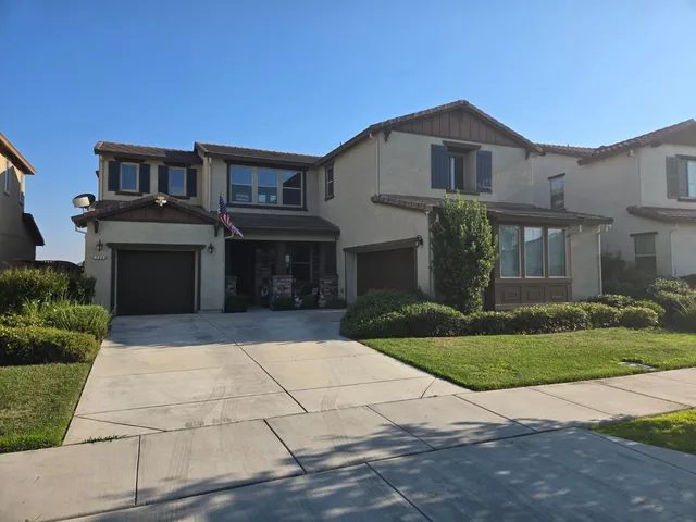 a front view of a house with a yard and a garage