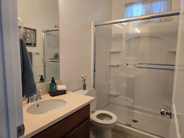 a bathroom with a sink a toilet and shower