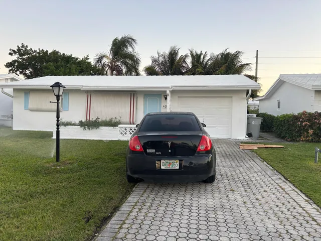 a car parked in front of a house and a yard