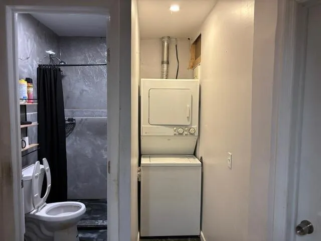 a bathroom with a granite countertop toilet and a shower