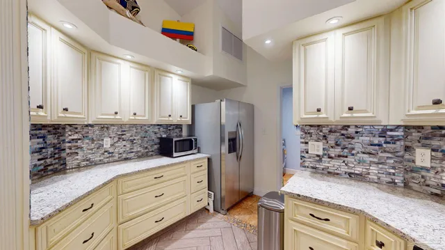 a kitchen with stainless steel appliances kitchen island granite countertop a stove a refrigerator and cabinets