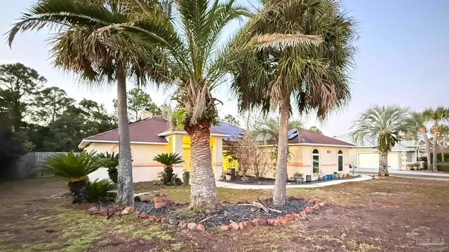 a palm tree sitting in front of a house with a yard