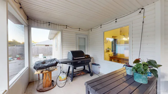 a backyard of a house with plants and large tree