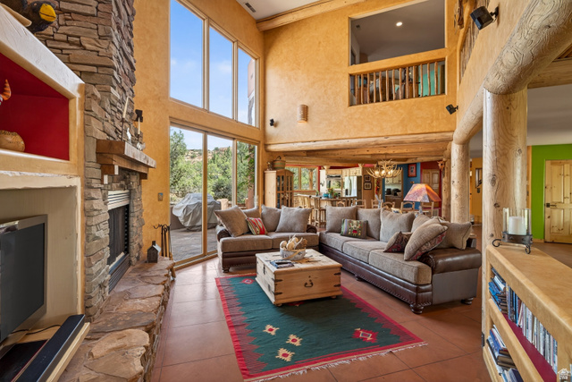 3617 Red Rock Drive Moab, UT 84532 - Photo 21 of 79 Living room with a high ceiling, a stone fireplace, and hanging lights