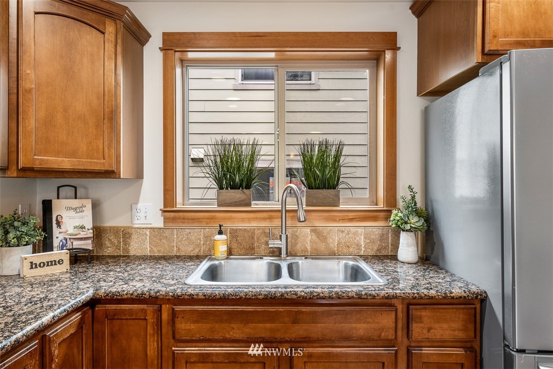 1122 North 92nd Street, Unit B Seattle, WA 98103 - Photo 12 of 32 a kitchen with granite countertop a sink and a window