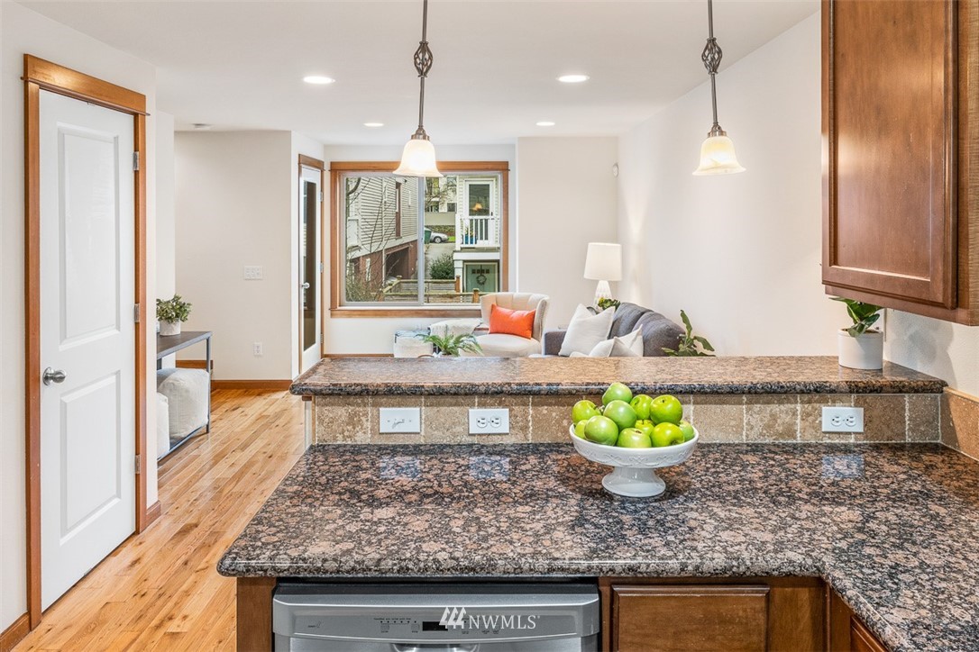 1122 North 92nd Street, Unit B Seattle, WA 98103 - Photo 14 of 32 a kitchen with stainless steel appliances granite countertop a stove a sink and a wooden cabinets
