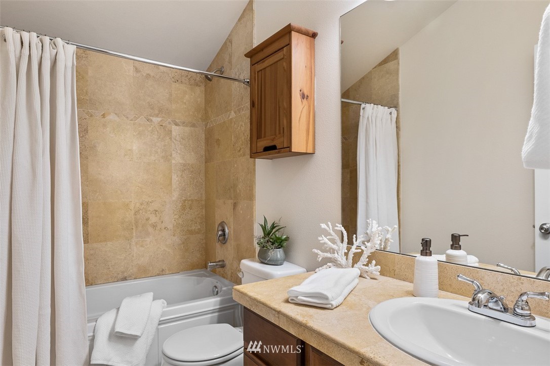 1122 North 92nd Street, Unit B Seattle, WA 98103 - Photo 23 of 32 a bathroom with a granite countertop sink toilet and shower